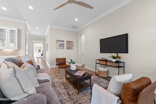 living room with hardwood / wood-style flooring, ceiling fan, and crown molding