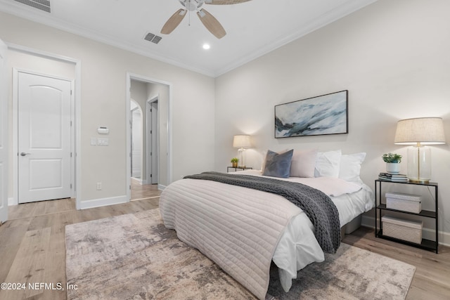 bedroom featuring ceiling fan, ornamental molding, and light wood-type flooring