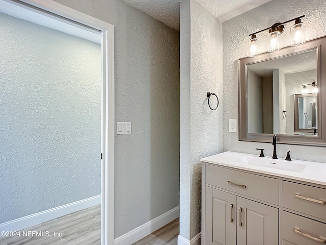 bathroom with vanity, a textured ceiling, and hardwood / wood-style floors