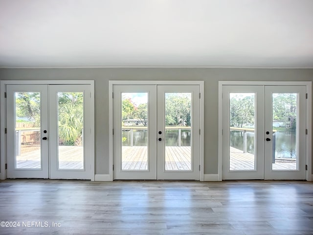 doorway to outside with ornamental molding, french doors, and light hardwood / wood-style floors