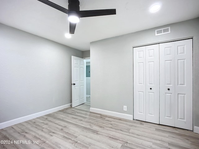 unfurnished bedroom with a closet, light wood-type flooring, and ceiling fan