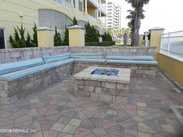 view of patio featuring a balcony, a jacuzzi, and an outdoor fire pit