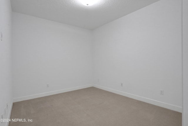 1031 1st St S Unit 504, Jacksonville Beach, FL 32250 - carpeted empty room featuring baseboards and a textured ceiling