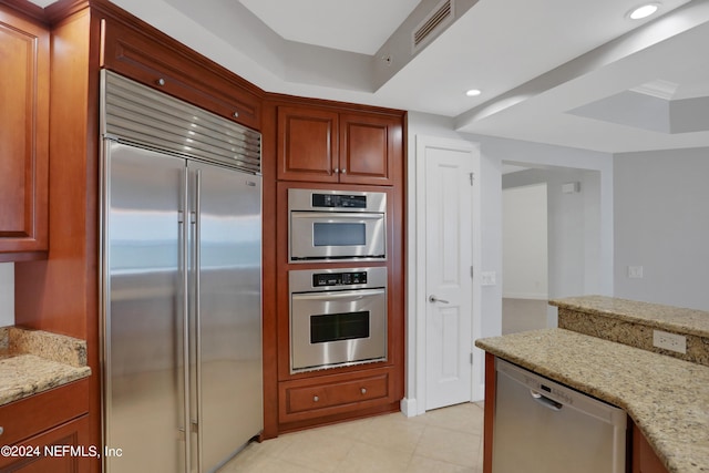 kitchen with light stone counters and appliances with stainless steel finishes