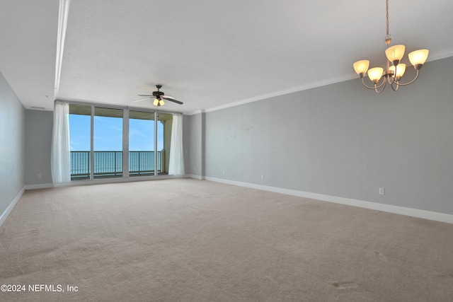 empty room with ceiling fan with notable chandelier, light carpet, and crown molding