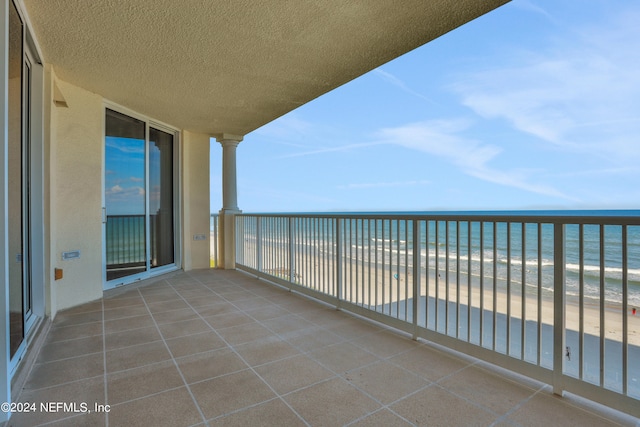 balcony featuring a water view and a view of the beach