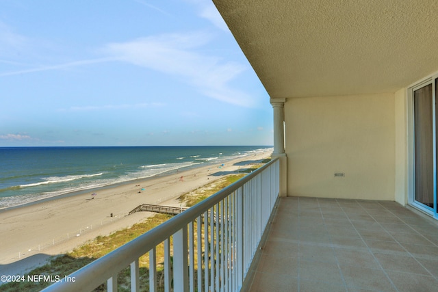 balcony with a water view and a beach view