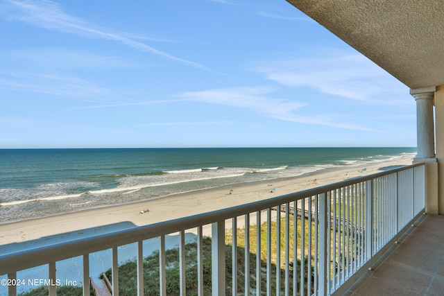 balcony featuring a beach view and a water view