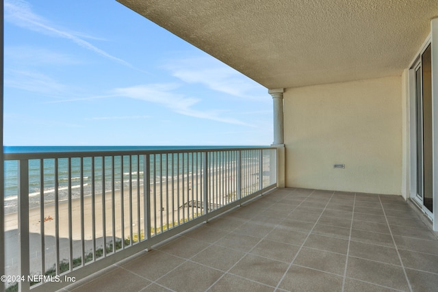 balcony with a water view and a beach view