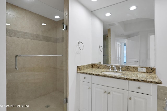 bathroom featuring vanity and a shower with door