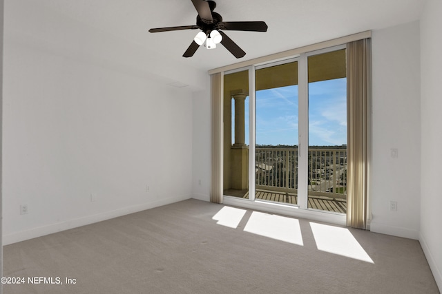 unfurnished room featuring ceiling fan, light colored carpet, and a wealth of natural light