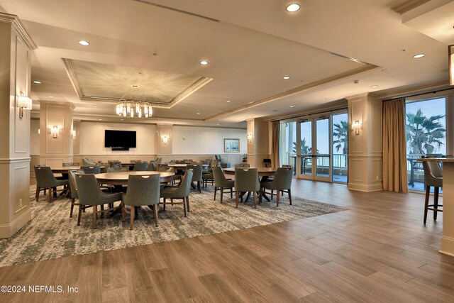1031 1st St S Unit 504, Jacksonville Beach, FL 32250 - dining area with a decorative wall, a chandelier, wood finished floors, recessed lighting, and a raised ceiling