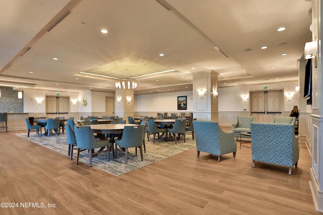 1031 1st St S Unit 504, Jacksonville Beach, FL 32250 - dining space featuring a decorative wall, recessed lighting, a raised ceiling, light wood-style floors, and wainscoting