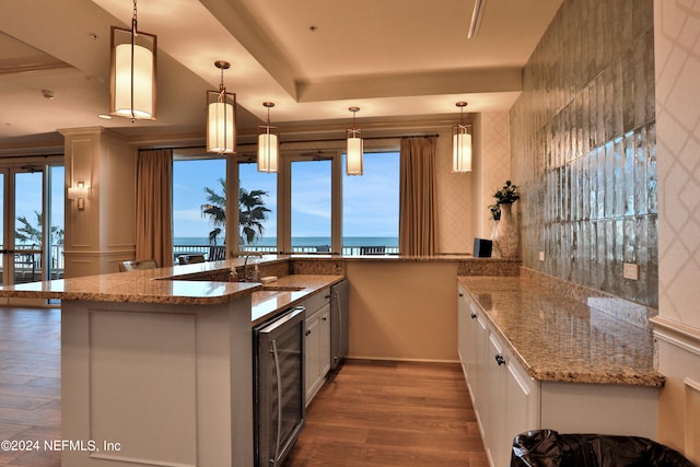 kitchen with wine cooler, hardwood / wood-style floors, a water view, and white cabinetry