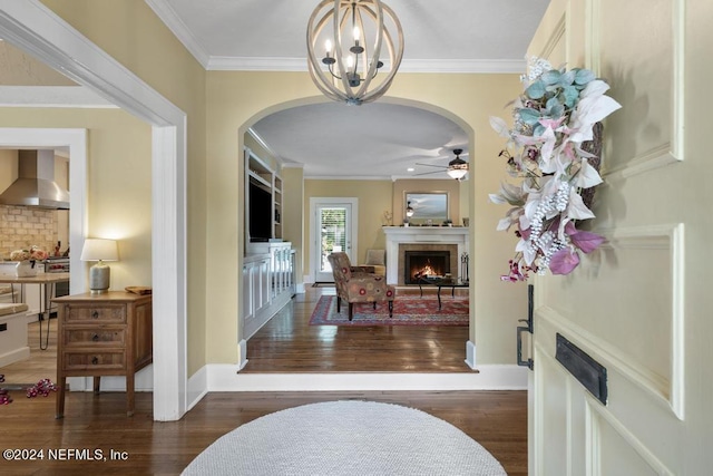 entrance foyer with ceiling fan with notable chandelier, dark hardwood / wood-style flooring, and crown molding