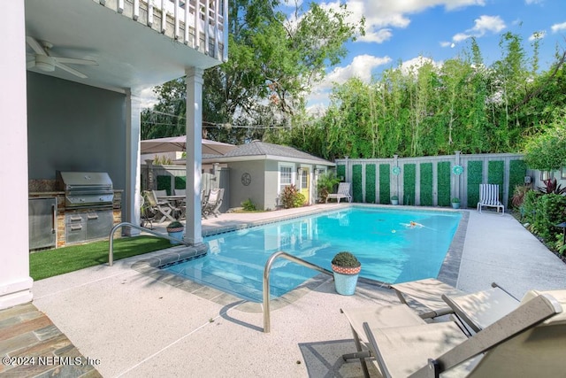 view of swimming pool with ceiling fan, a patio area, and grilling area