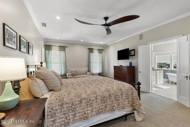 bedroom with ceiling fan, crown molding, light carpet, and connected bathroom