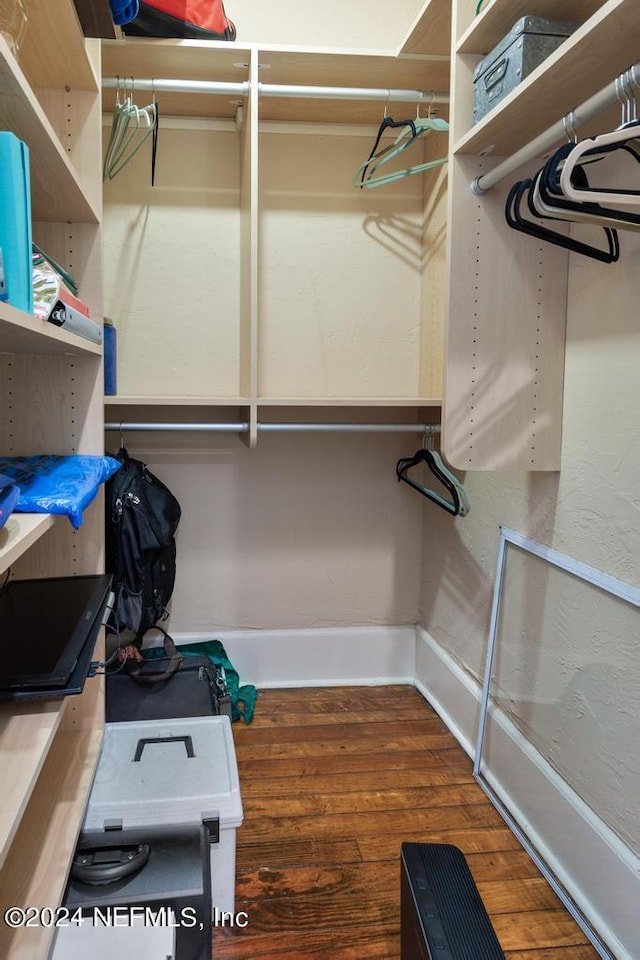 spacious closet with dark wood-type flooring