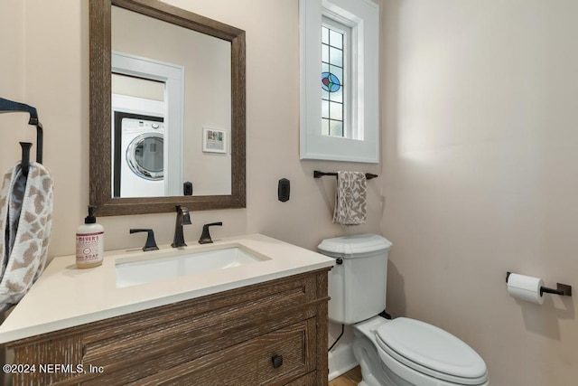 bathroom featuring toilet, washer / dryer, and vanity