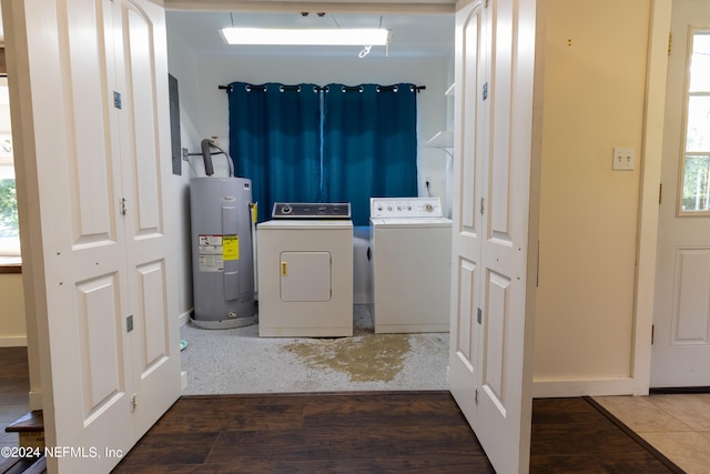 clothes washing area with electric water heater, dark hardwood / wood-style floors, and washer and clothes dryer