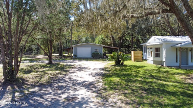 view of front of property with a front yard, a garage, and an outbuilding