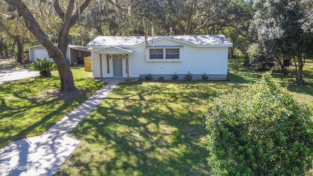 view of front of property featuring an outdoor structure, a front yard, and a garage