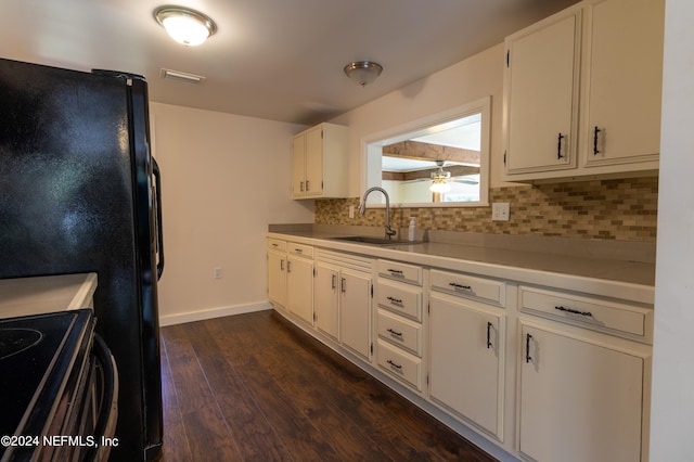 kitchen with black electric range oven, sink, tasteful backsplash, white cabinetry, and dark hardwood / wood-style floors