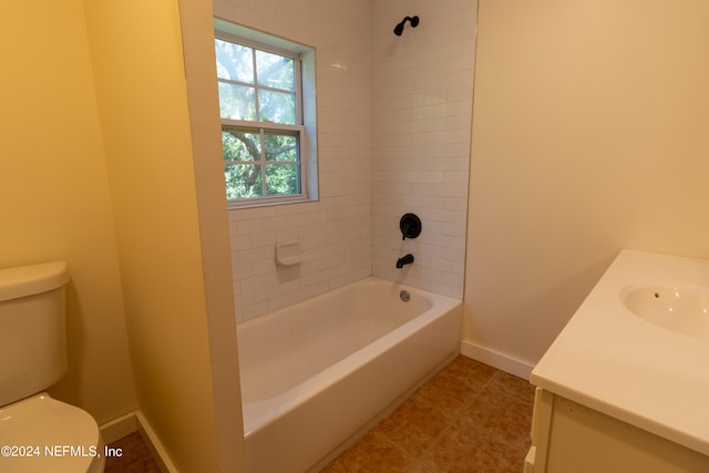 full bathroom featuring tile patterned floors, tiled shower / bath combo, vanity, and toilet