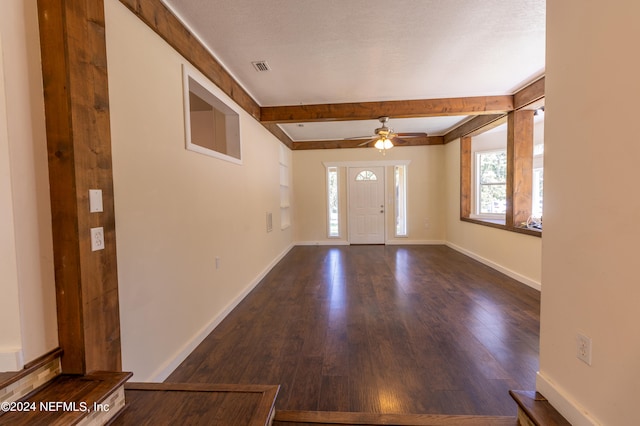 entrance foyer featuring a textured ceiling, beam ceiling, dark hardwood / wood-style floors, and ceiling fan