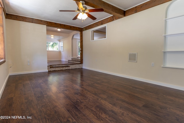 empty room with beam ceiling, dark hardwood / wood-style floors, and ceiling fan