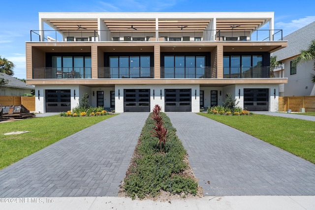 modern home featuring a balcony and a front yard