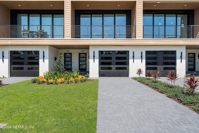 contemporary house with a balcony and a front yard