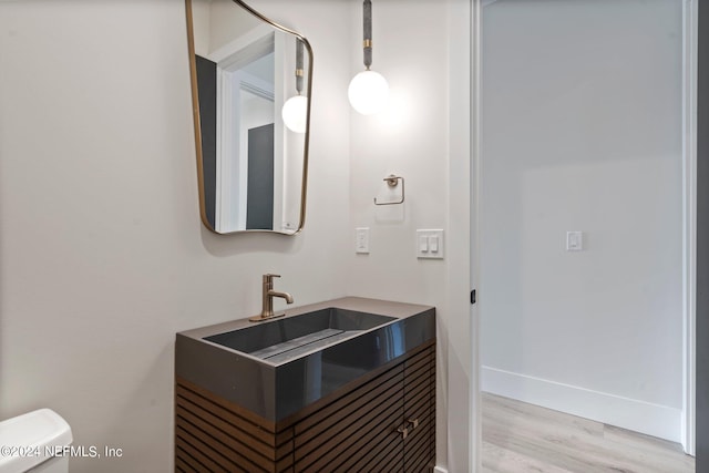 bathroom featuring toilet, sink, and hardwood / wood-style flooring