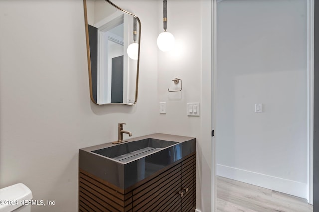 121 12th Ave S, Jacksonville Beach, FL 32250 - half bathroom with toilet, wood finished floors, vanity, and baseboards
