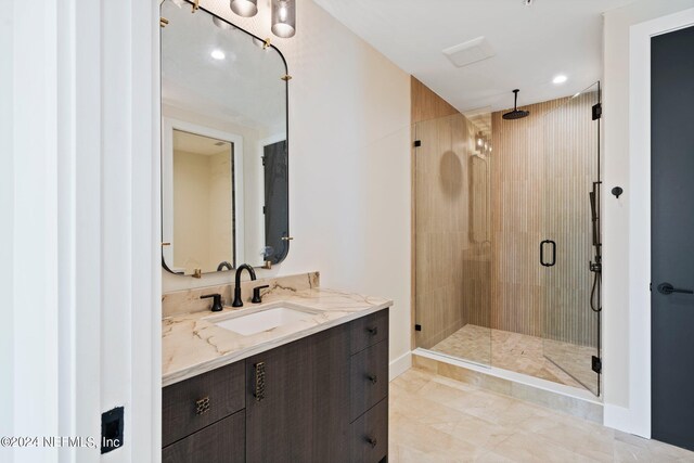 bathroom with a shower with shower door and vanity