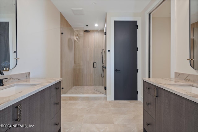 bathroom featuring a shower with shower door and vanity