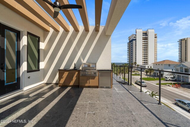 balcony with grilling area, ceiling fan, and exterior kitchen