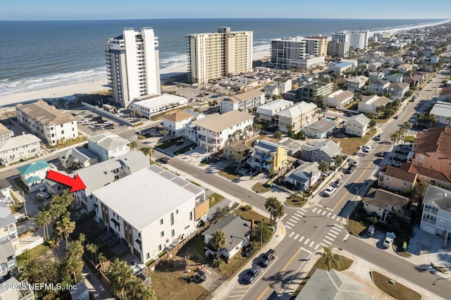 bird's eye view with a water view and a beach view