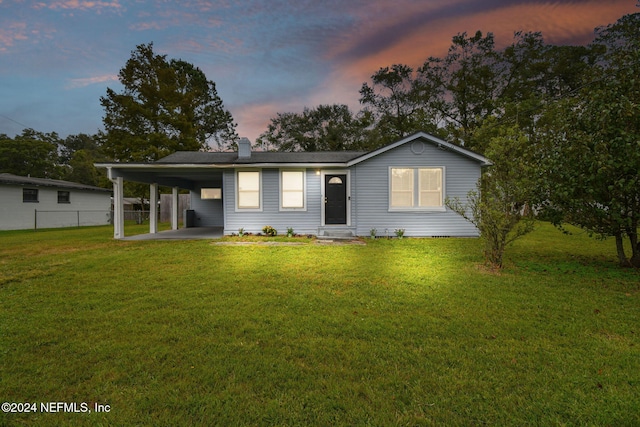 view of front facade with a yard and a carport