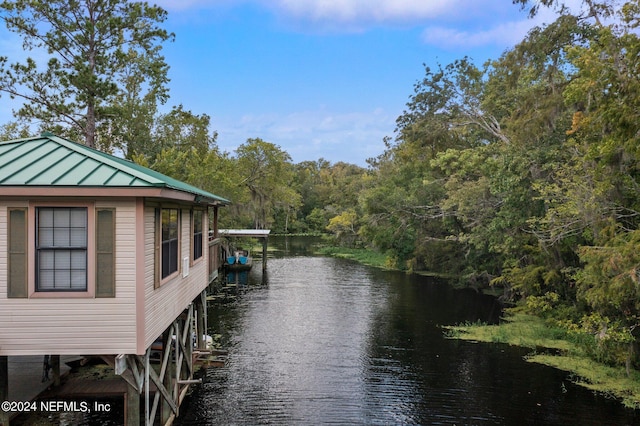 view of dock with a forest view and a water view