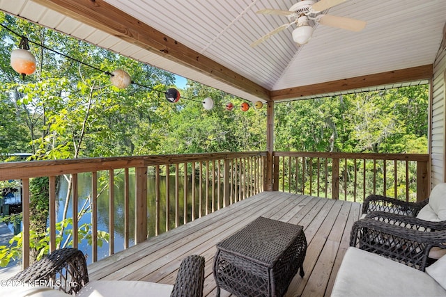 wooden terrace with a water view and ceiling fan