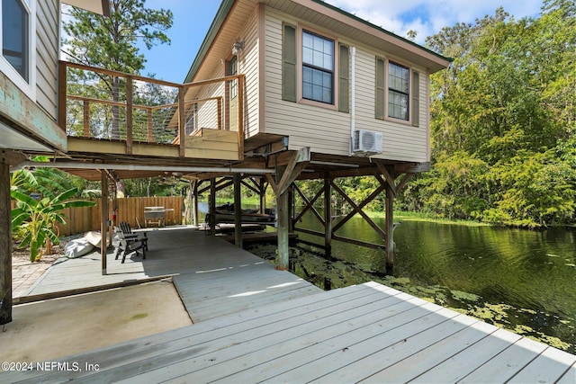 view of dock with a deck with water view and fence