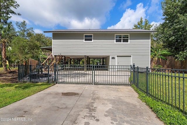 view of front of property with metal roof, fence, concrete driveway, and a front yard