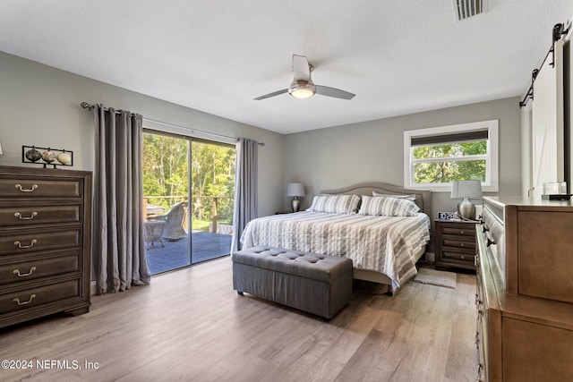 bedroom featuring multiple windows, access to exterior, ceiling fan, and light wood-type flooring