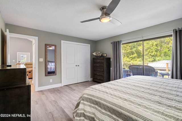 bedroom featuring a closet, access to outside, ceiling fan, a textured ceiling, and light hardwood / wood-style flooring