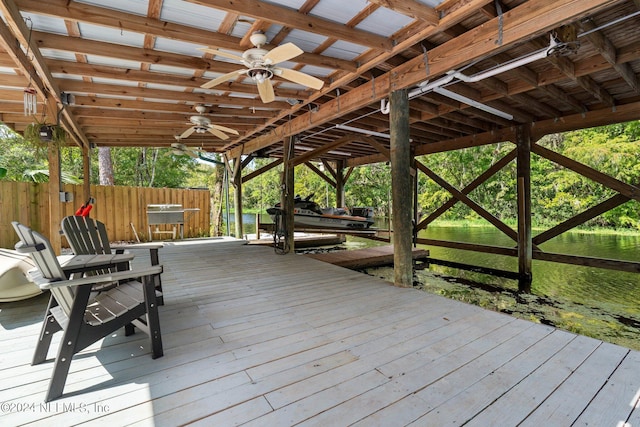 wooden terrace with boat lift, a boat dock, and ceiling fan