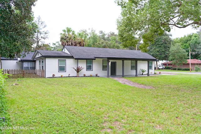 ranch-style house featuring roof with shingles and a front lawn