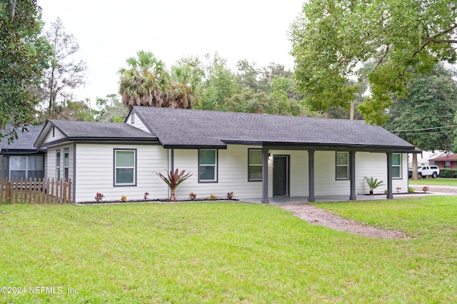 ranch-style house featuring a front lawn and roof with shingles