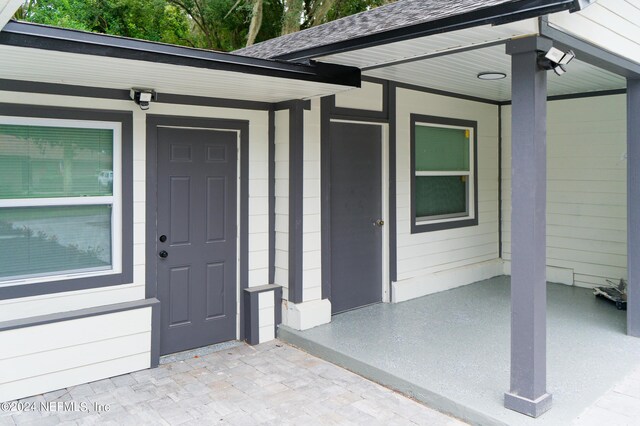 view of exterior entry featuring covered porch
