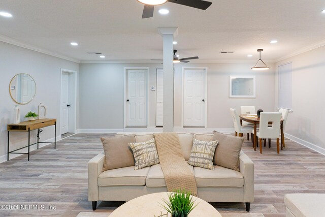 living room featuring ceiling fan, light hardwood / wood-style flooring, and crown molding